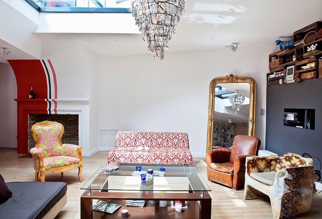 Various armchairs and sofa around coffee table with gilt-framed mirror in background and wooden crates on top of partition