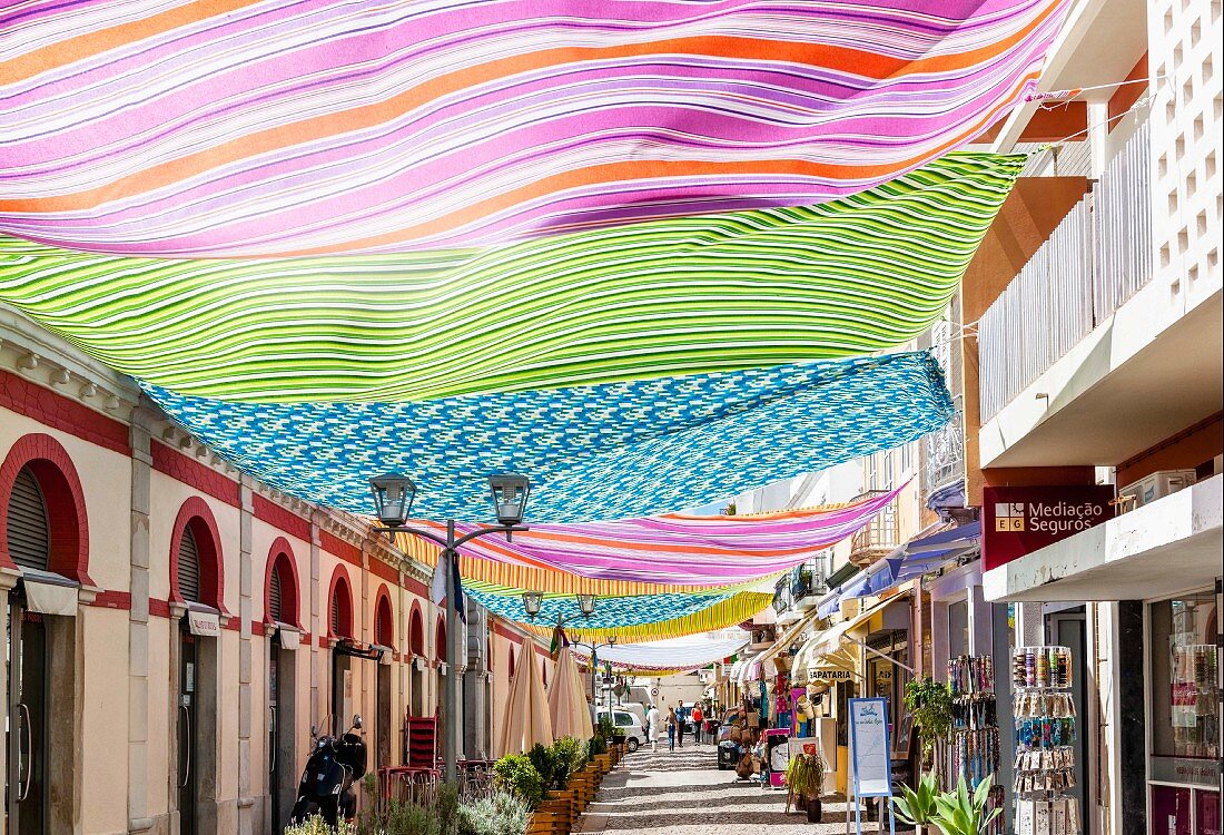 A lane decorated with colourful cloths in the old city centre of Loulé in the Algarve region of Portugal