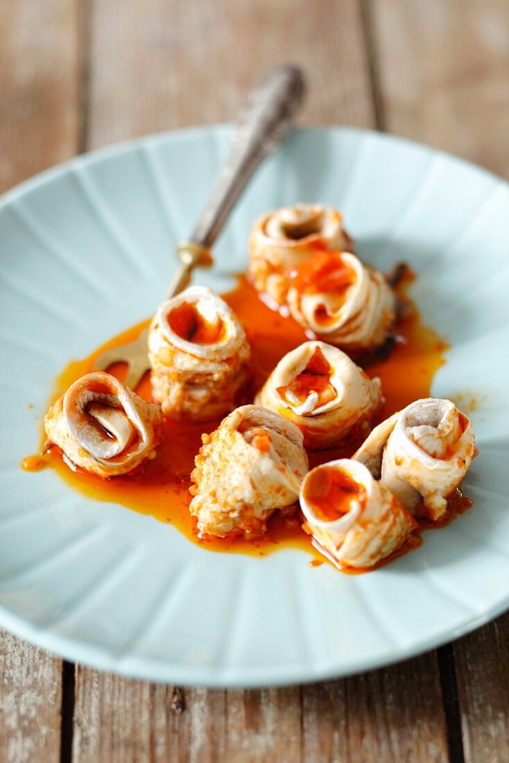 Herring rolls with onion and a spicy tomato sauce