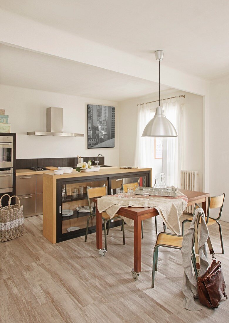 Dining table, retro chairs and sideboard in front of kitchen counter