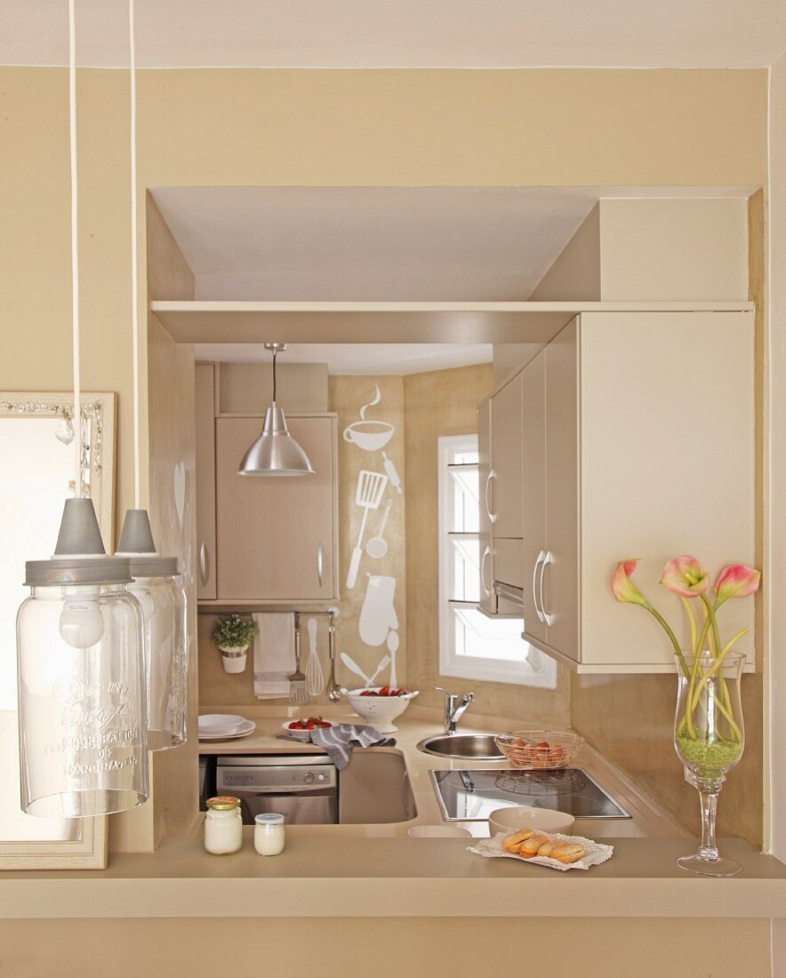 View through serving hatch into beige kitchen