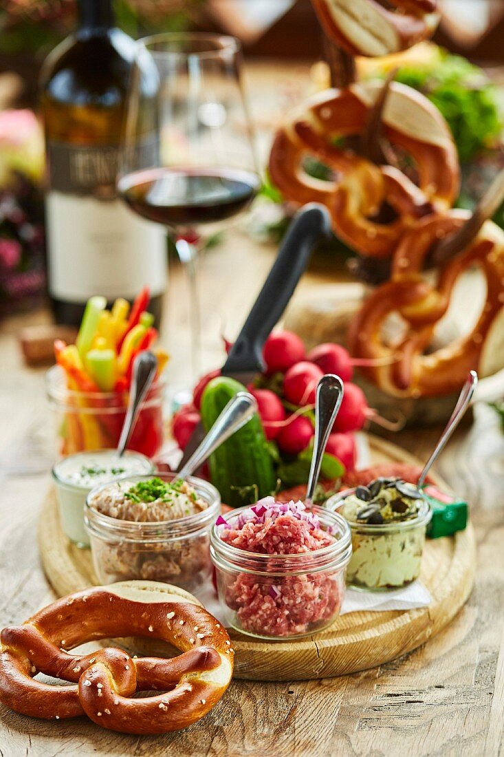 Brettljause (Bavarian ploughman's lunch) with pretzels, dips, vegetables and red wine
