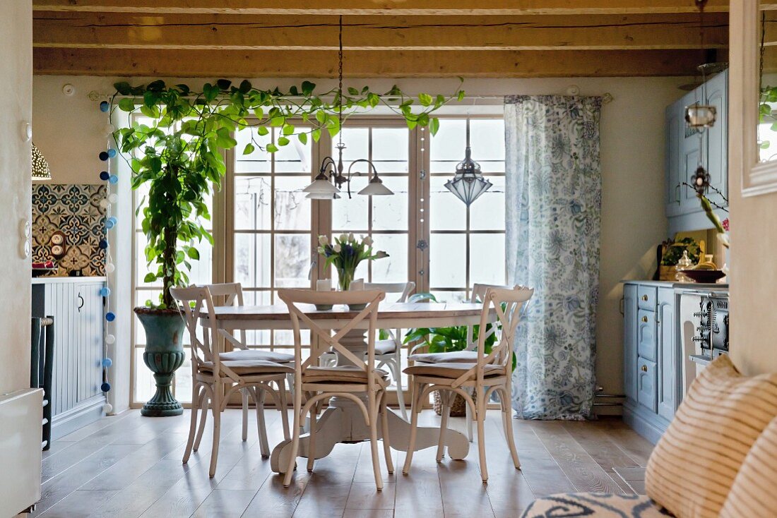 Cosy dining area with round table and rustic wood-beamed ceiling