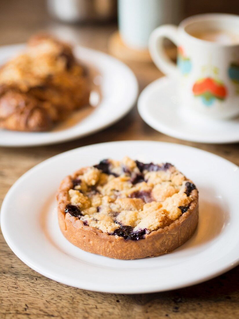 Berry crumble tartlet with a cup of coffee in a French café