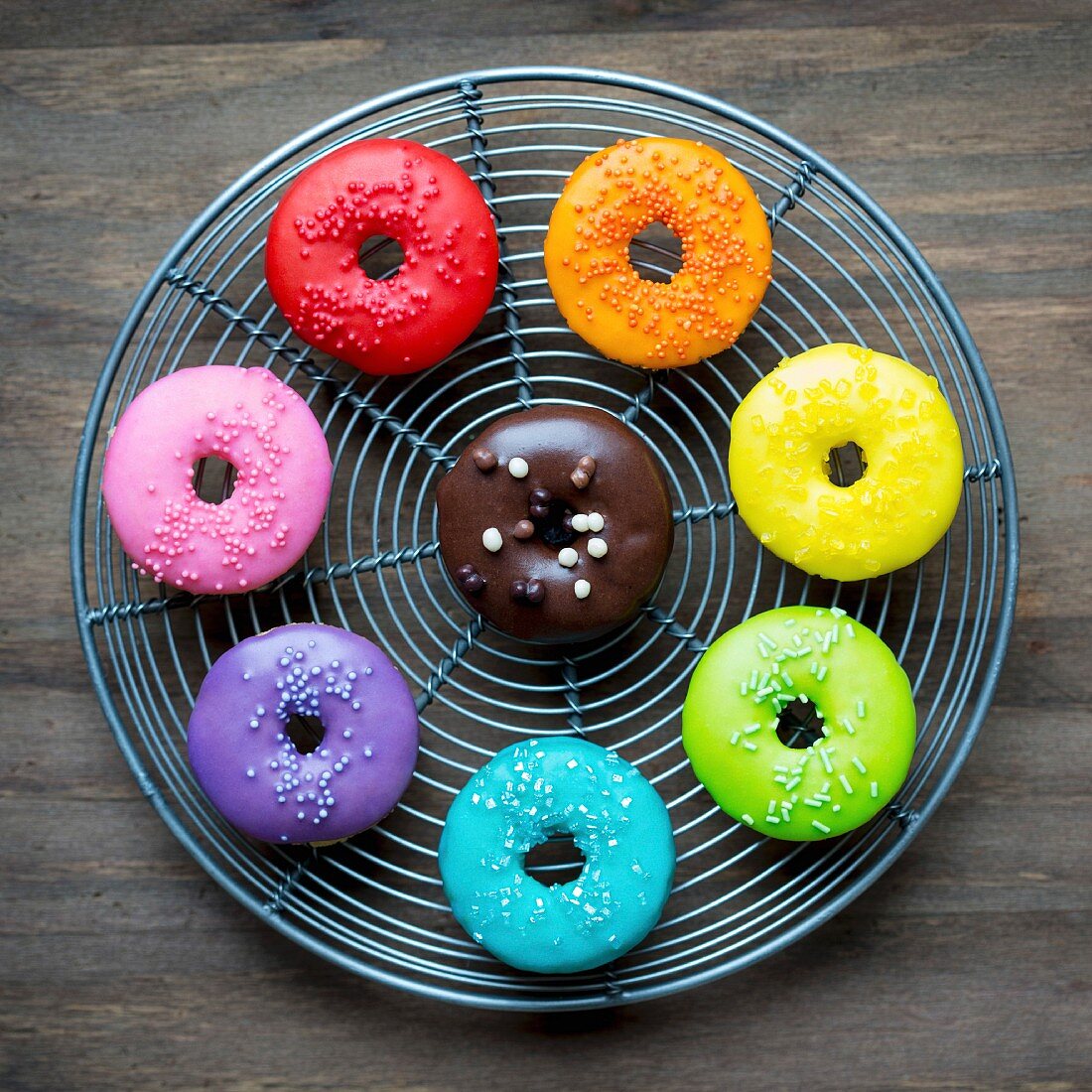 Colorful glazed donuts on a wire rack