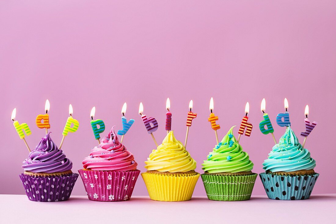 Bunte Cupcakes mit 'Happy birthday' Buchstaben verziert