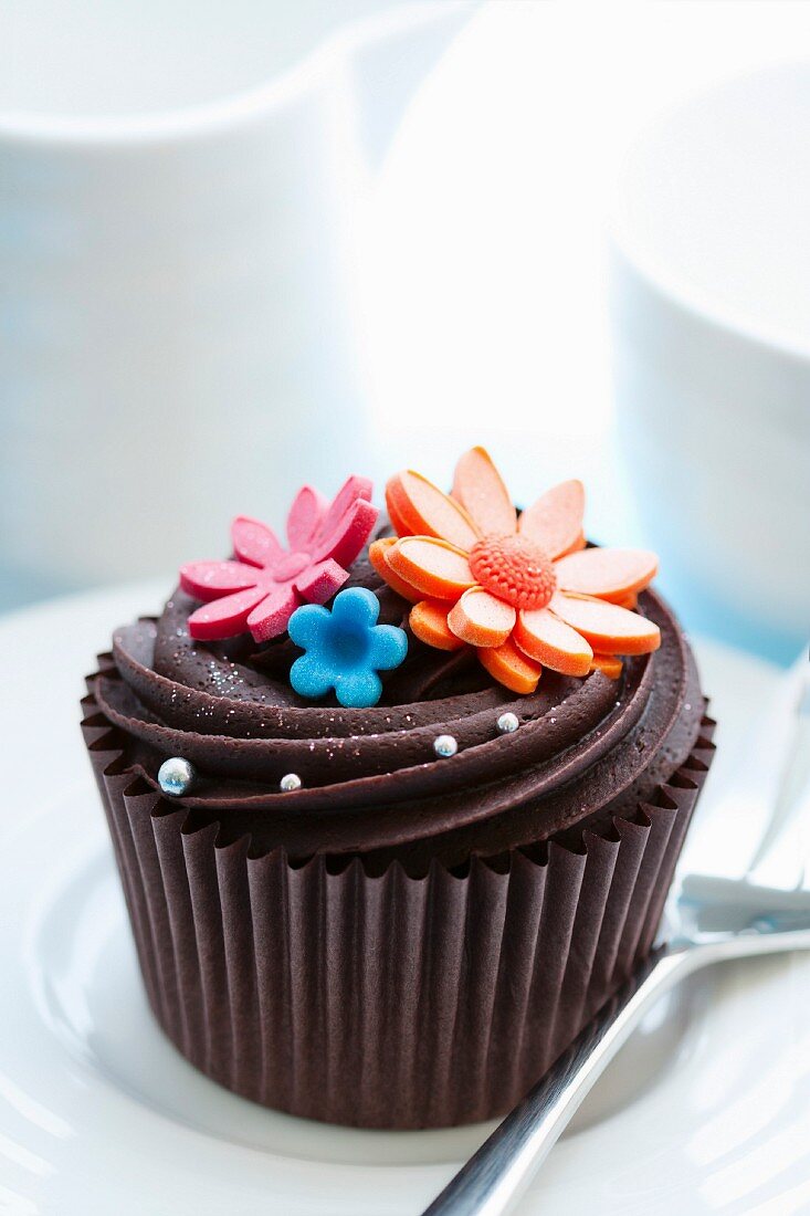 Cupcake decorated with chocolate ganache and sugar flowers