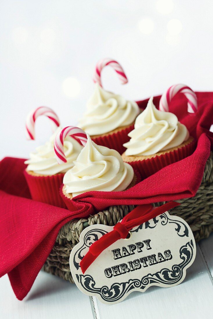 Weihnachtliche Cupcakes mit Zuckerstange in einem Geschenkkorb