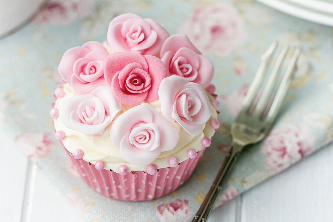 Cupcake mit rosa Zuckerrosen verziert