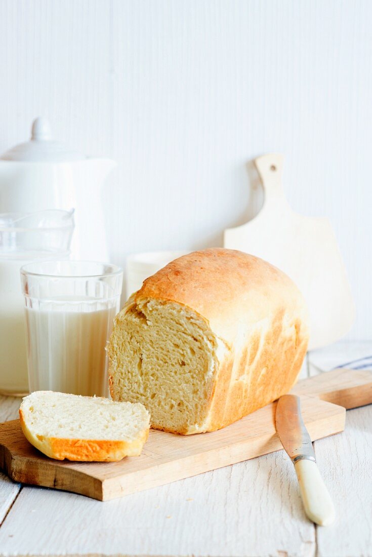 A sliced loaf od home-made milk bread on a chopping board