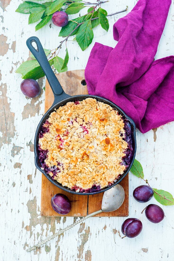 Pflaumencrumble in Bratpfanne mit Haferflocken und Mandelblättchen