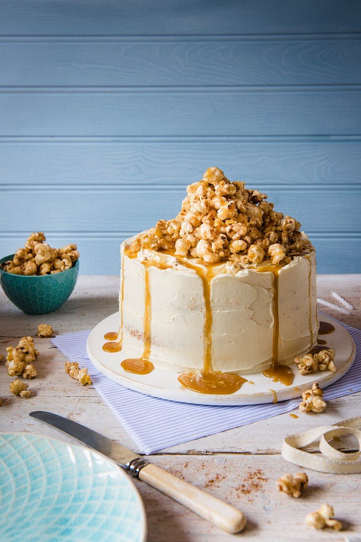 A cake with white chocolate buttercream icing and cinnamon toffee popcorn