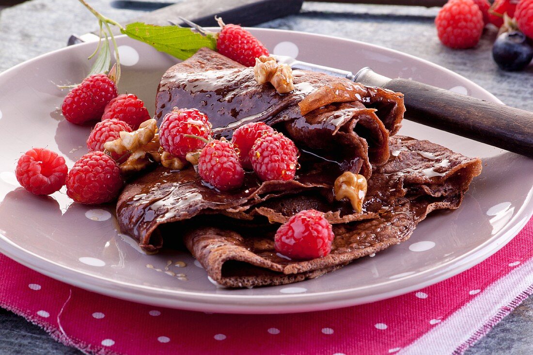 Chocolate crêpes with raspberries, walnuts and maple syrup