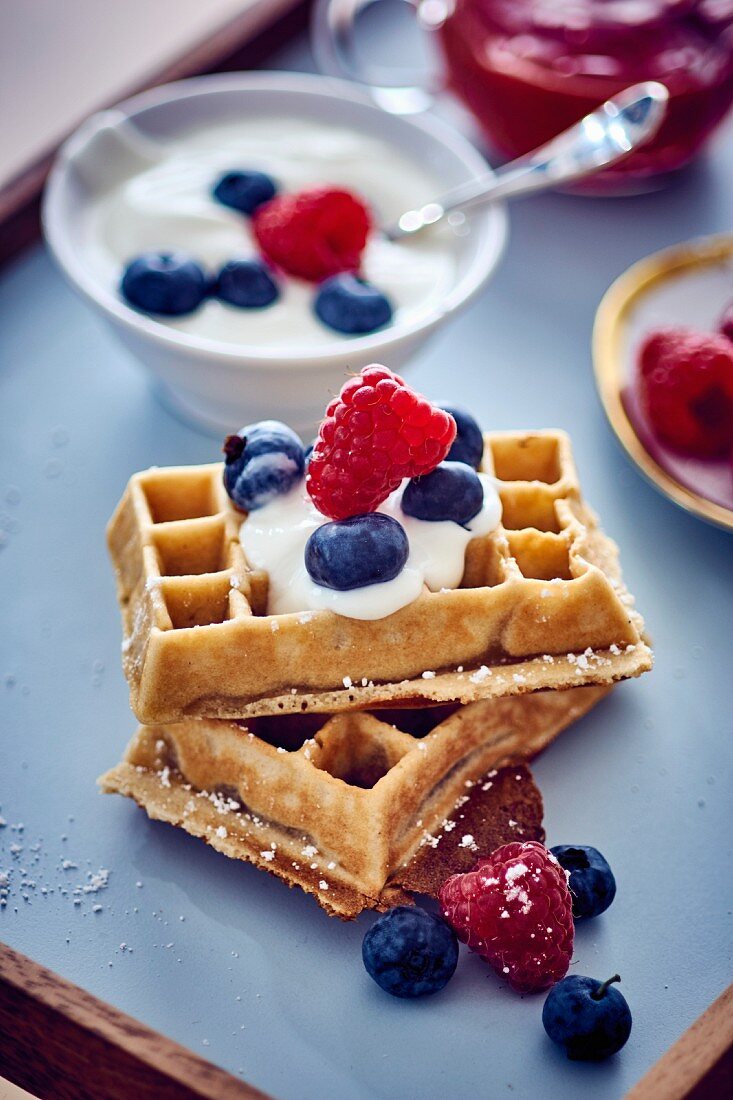 A waffle with cherries with blueberries
