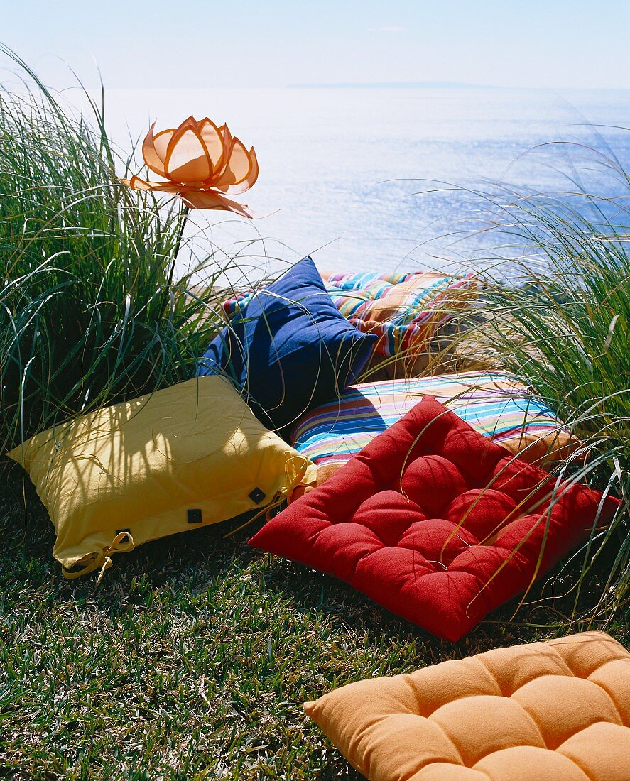 Bunte Kissen auf der Wiese am Meer