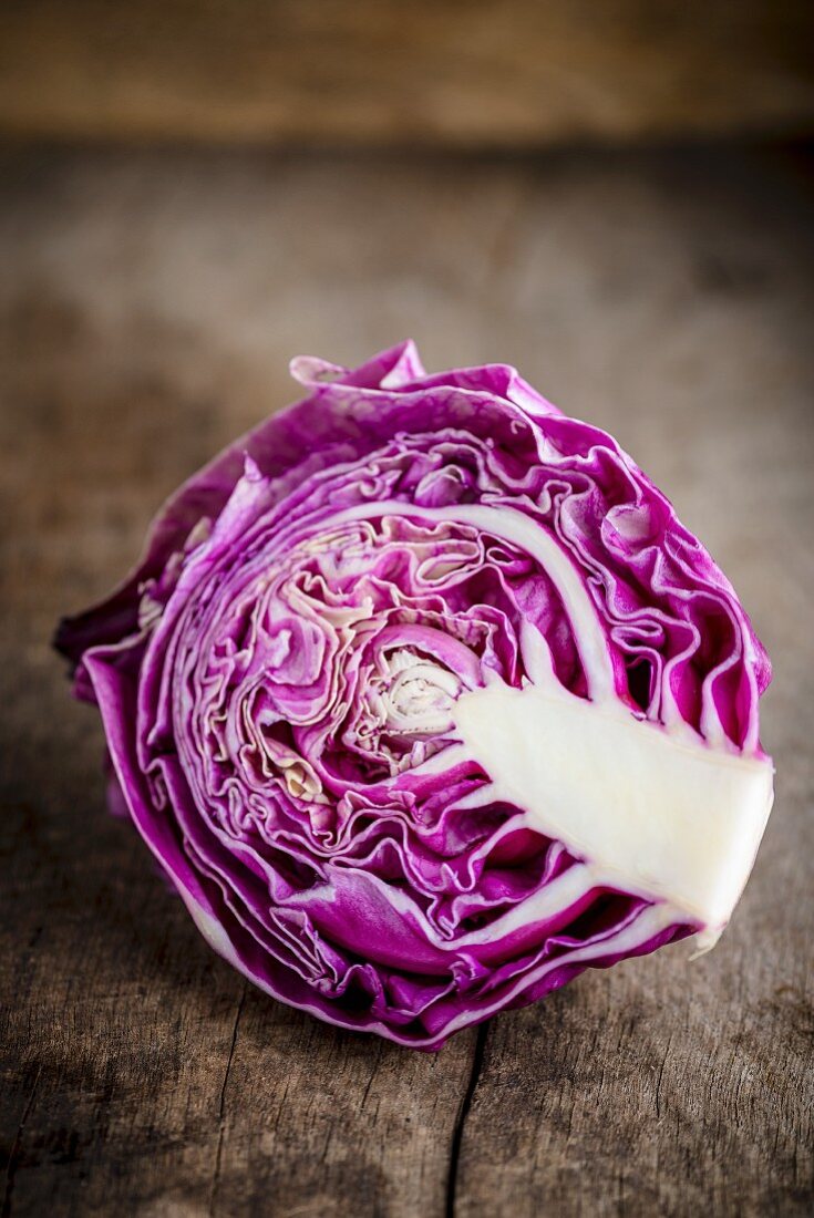 Half a red cabbage on a wooden surface