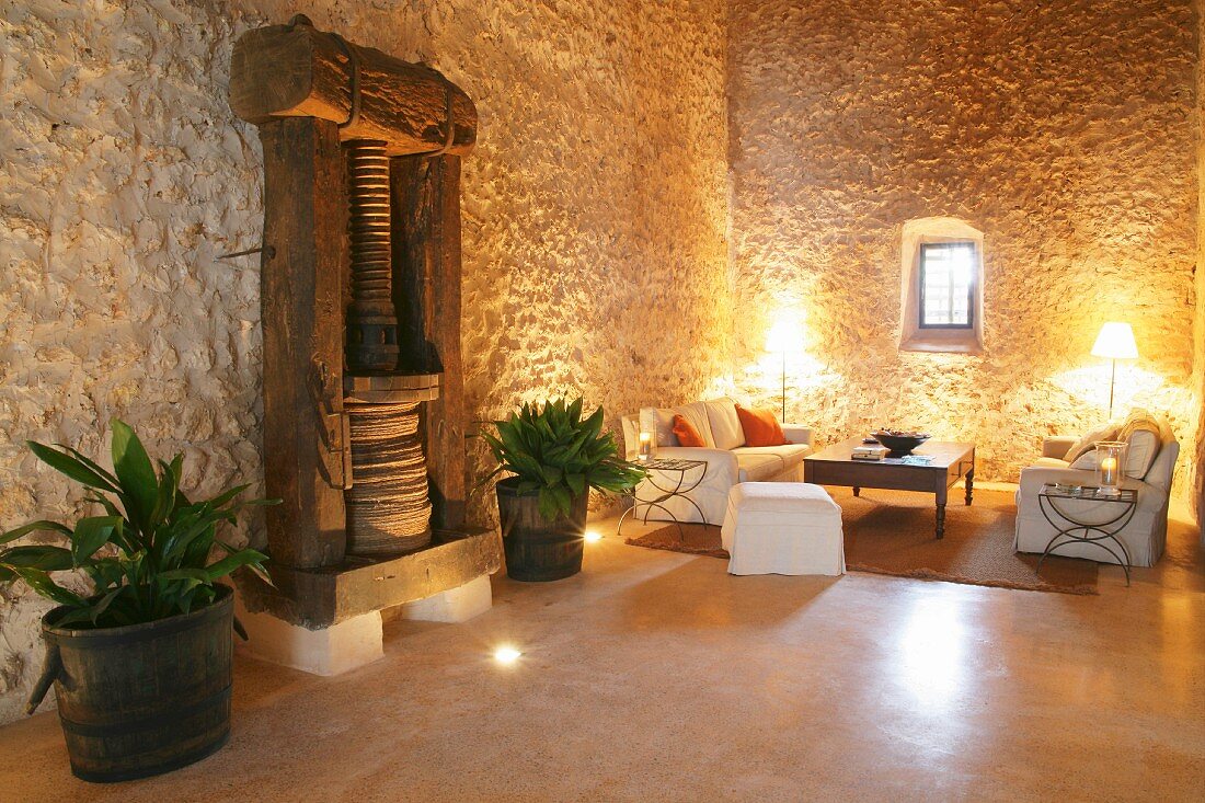 Ancient wooden press against stone wall in Mediterranean living room