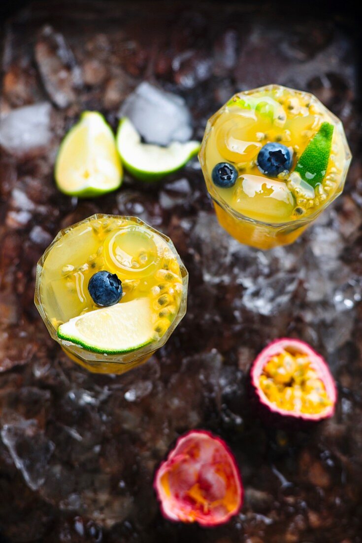 An orange drink with passionfruit, lime and blueberry