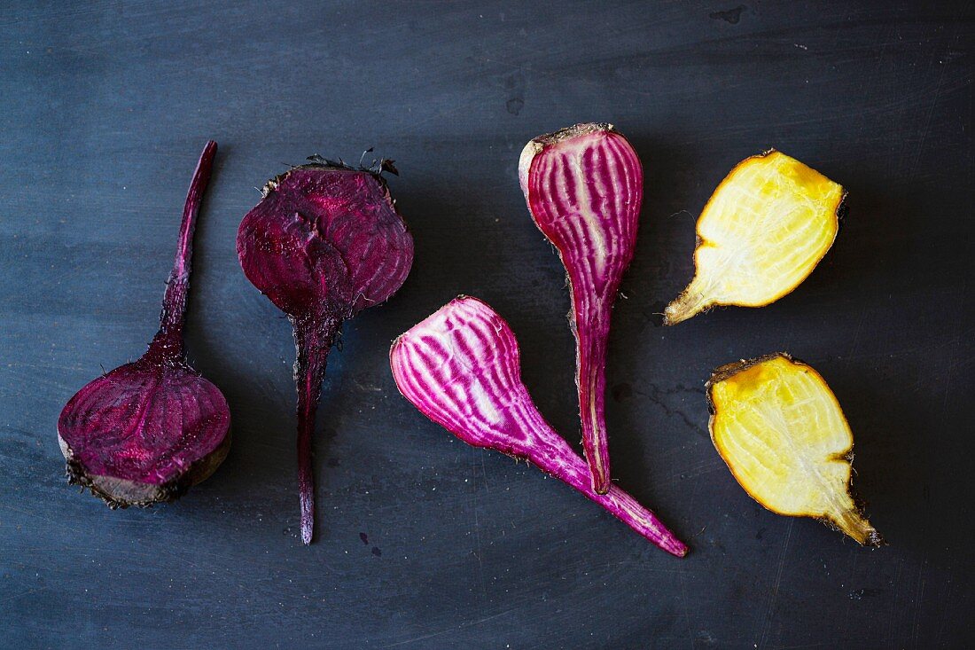 Yellow and purple beetroots on a dark surface