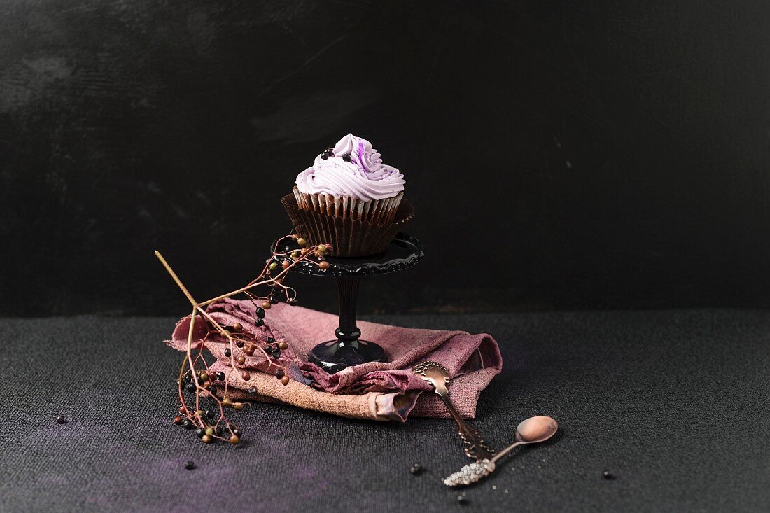 A cupcake with an elderberry topping