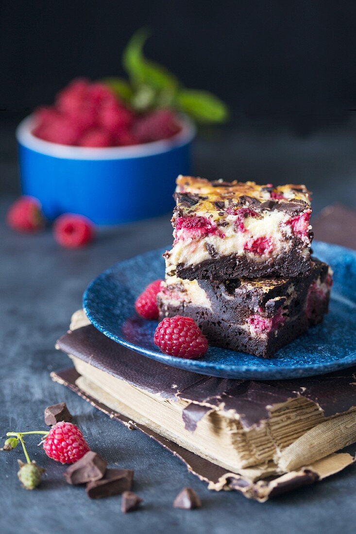 Cheesecake brownie bars with raspberries on a plate