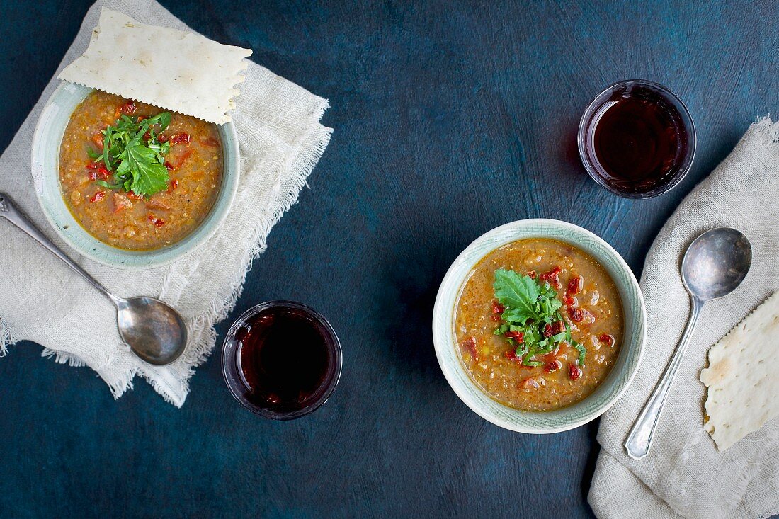 Red Lentil Soup topped with sun dried tomato and arugula in ceramic bowls