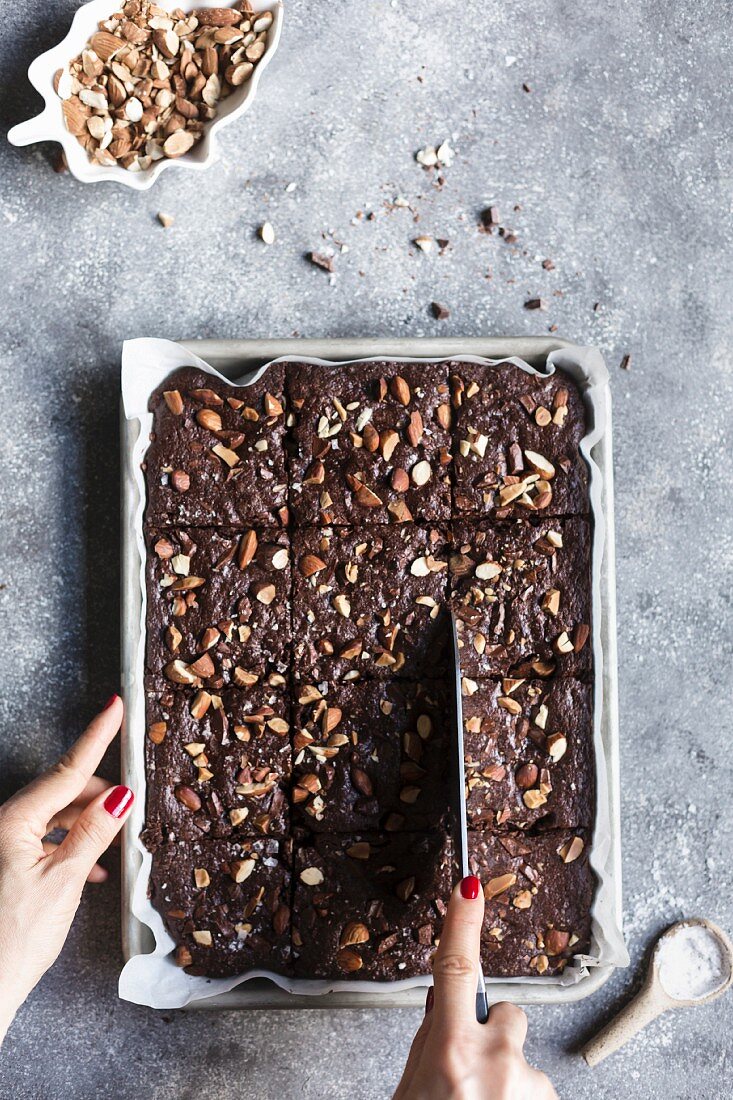 Frau schneidet Brownie in Stücke