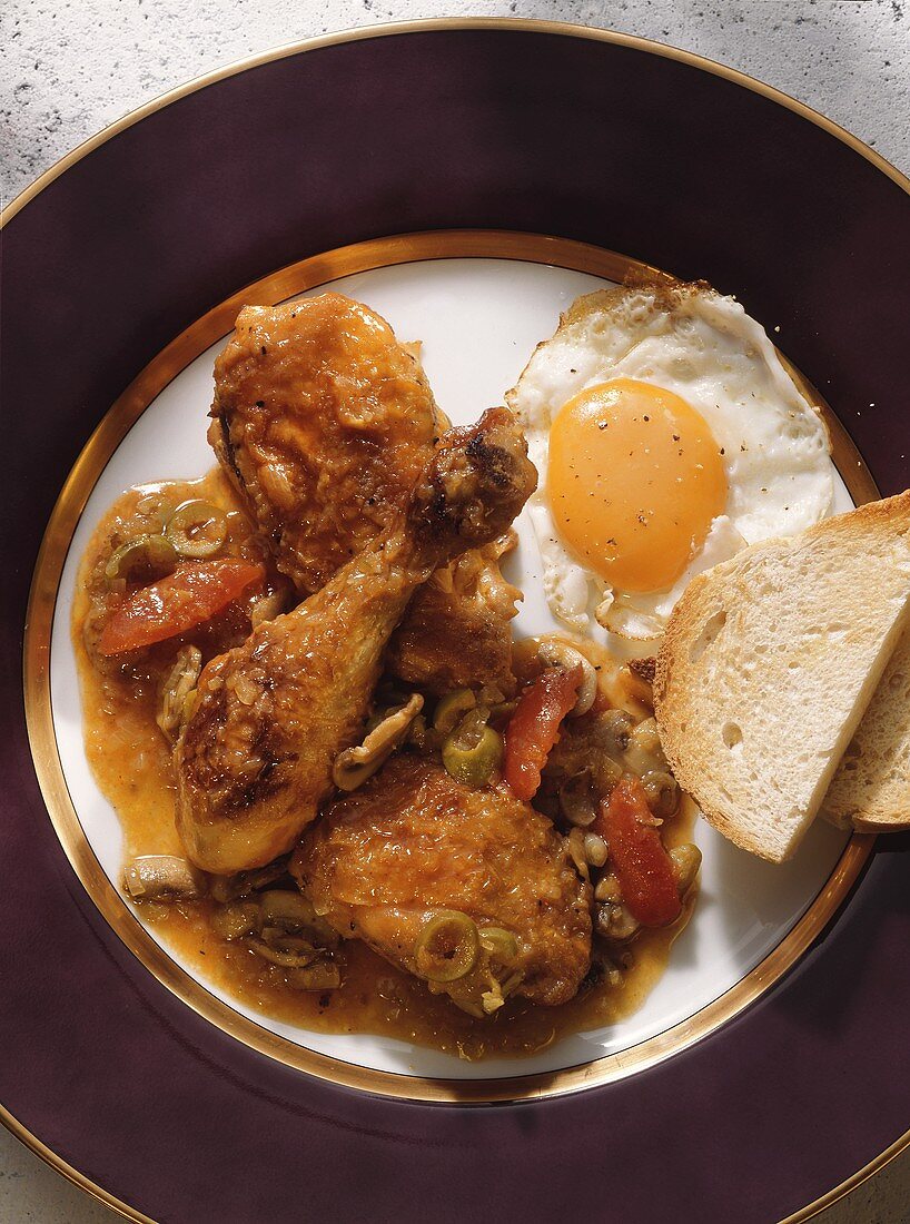 Hühnerragout Marengo mit Spiegelei auf Teller