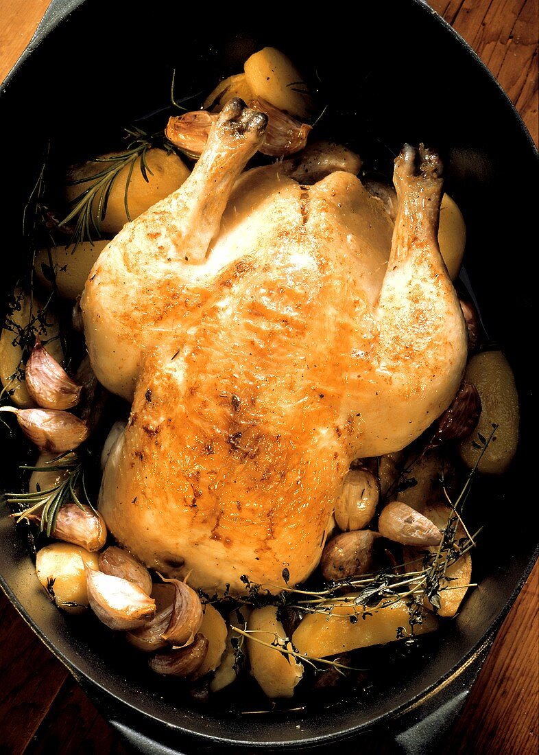 Whole Cooked Chicken with Garlic in Roasting Pan
