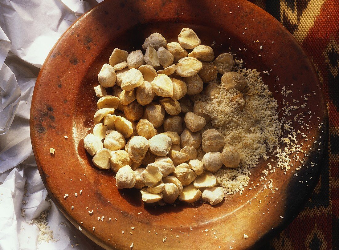 Whole and Ground Kemiri Nuts in a Bowl