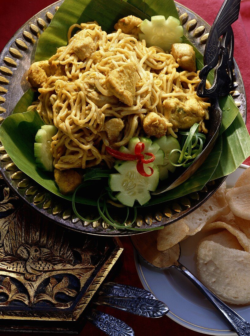 Curried noodles with chicken on plate and banana leaves