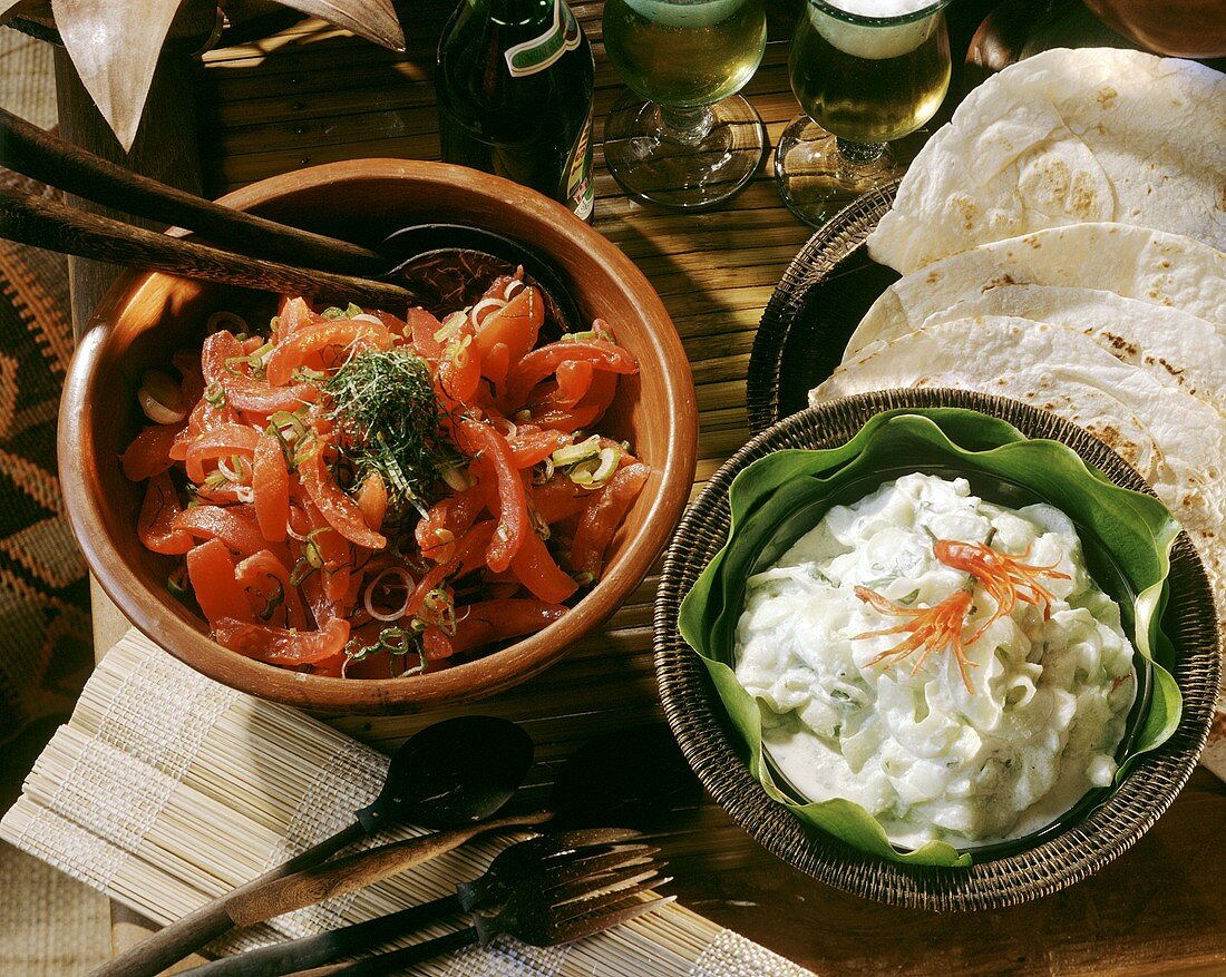 Tomato and Mint Salad and Cucumber in Yogurt Dressing in bowls with Flour Tortillas