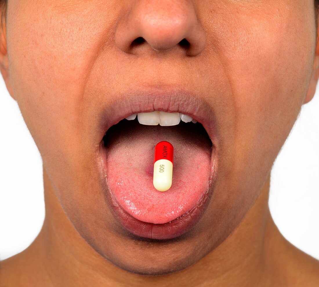 Woman taking an antibiotic capsule
