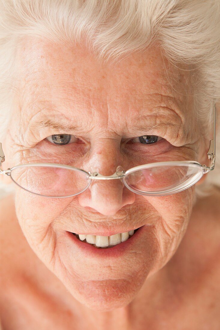 Elderly woman using reading glasses