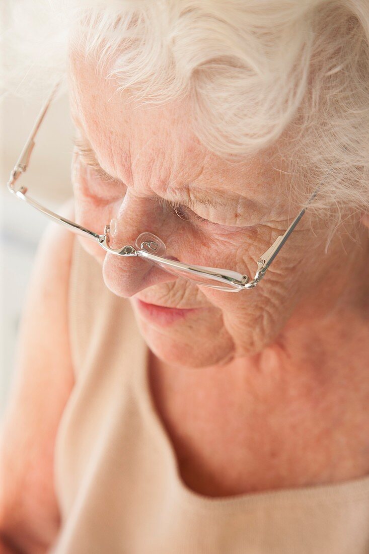 Elderly woman using reading glasses
