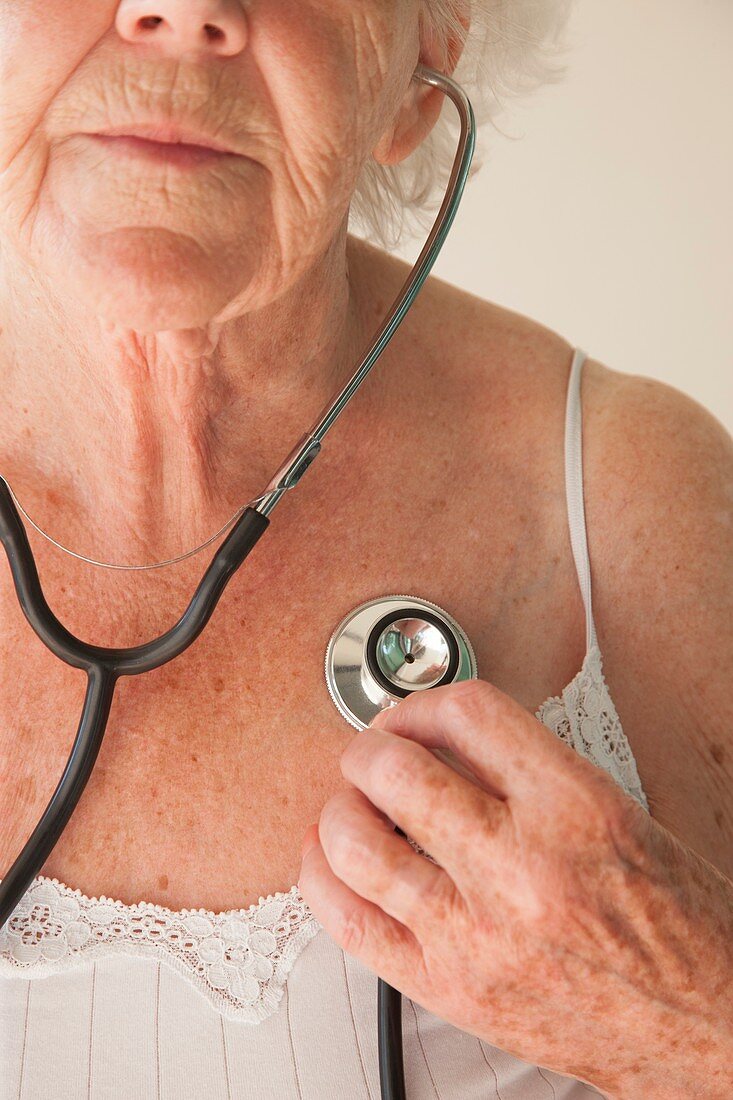 Elderly woman using a stethoscope