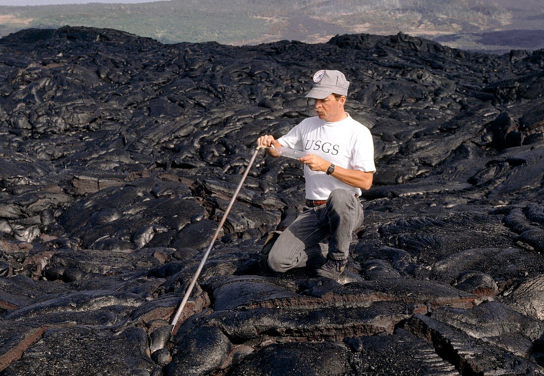 Geologist studying gas sample from lava on volcano