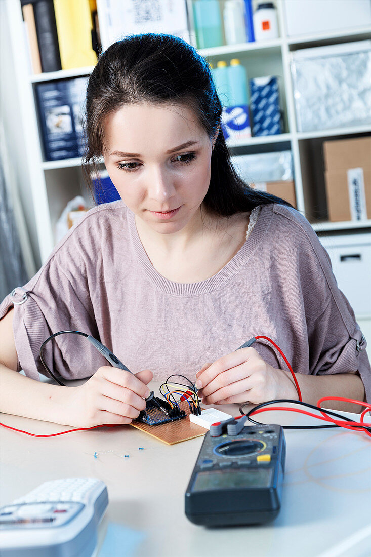 Technician soldering wires on multimetre