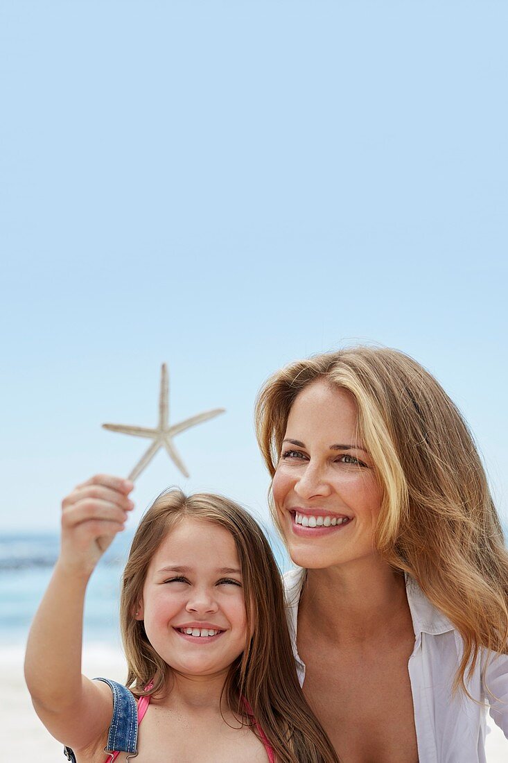 Mother with daughter holding a starfish