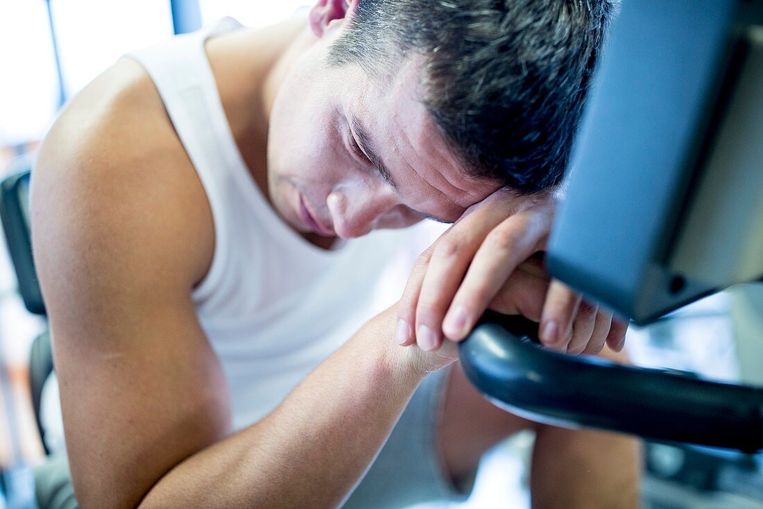 Man resting his head on exercise machine