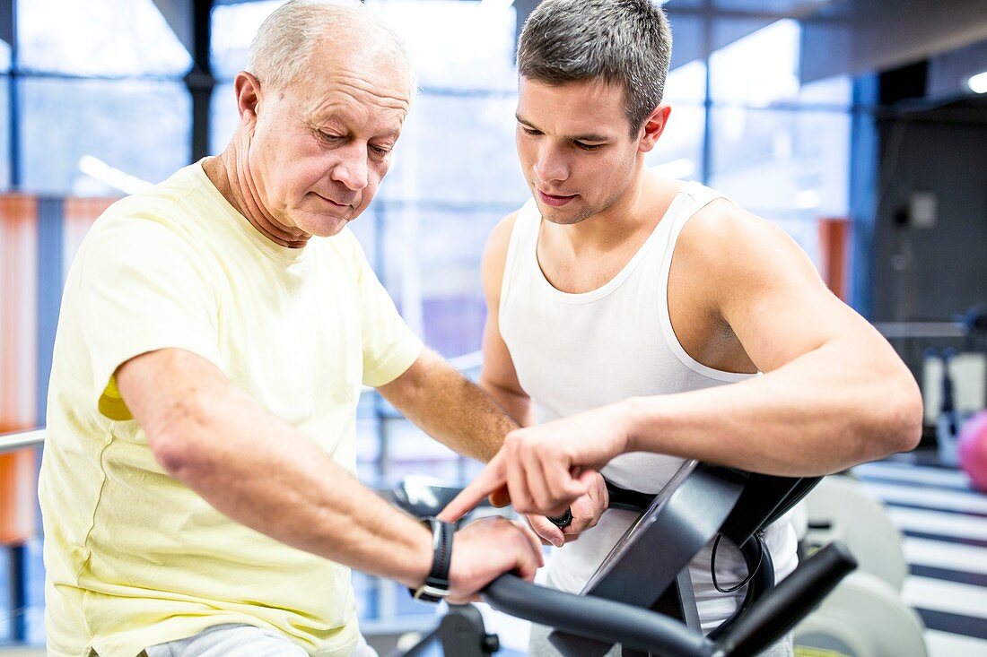 Senior man exercising with trainer