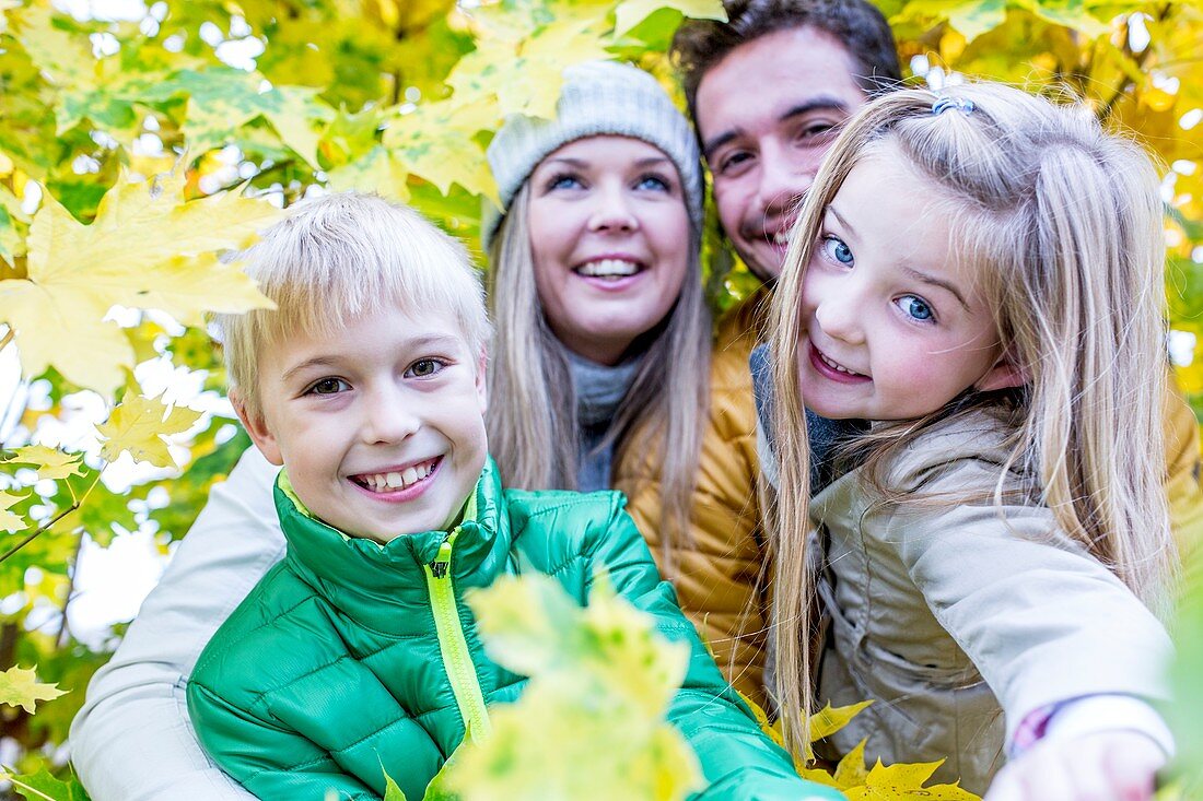 Family surrounded by autumn leaves