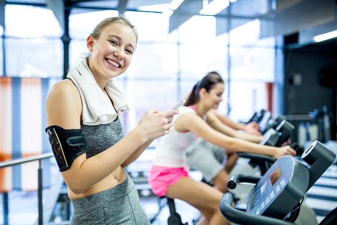 Woman using phone in gym