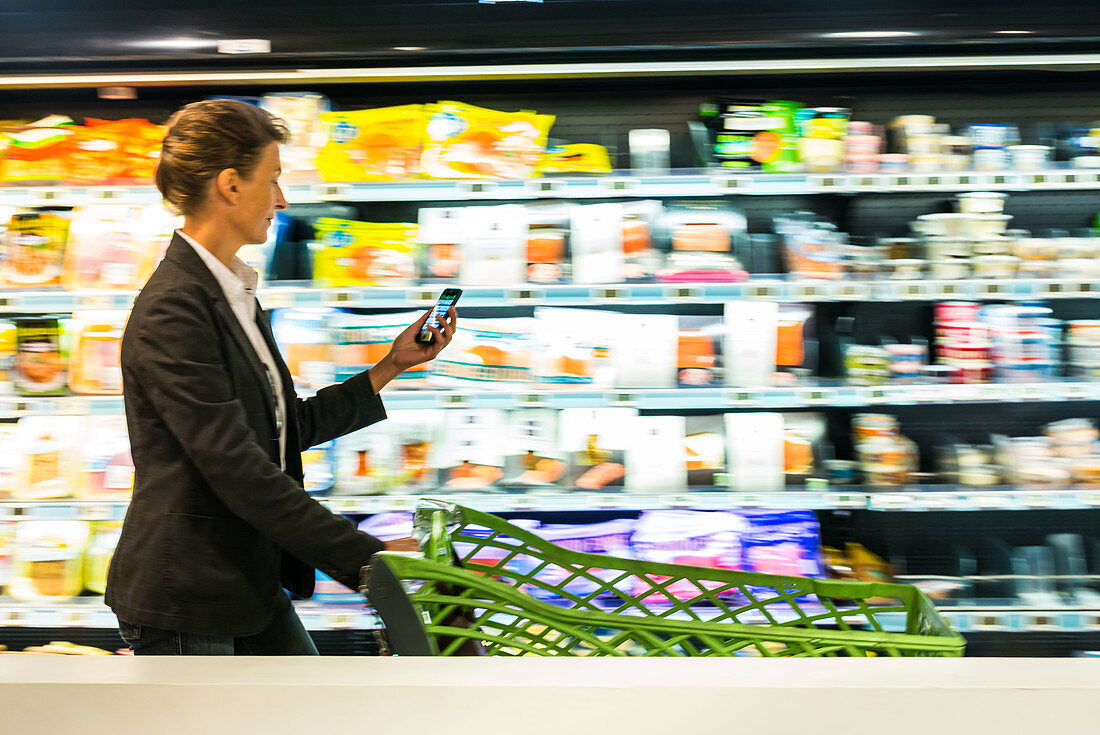 Woman using a smartphone in supermarket