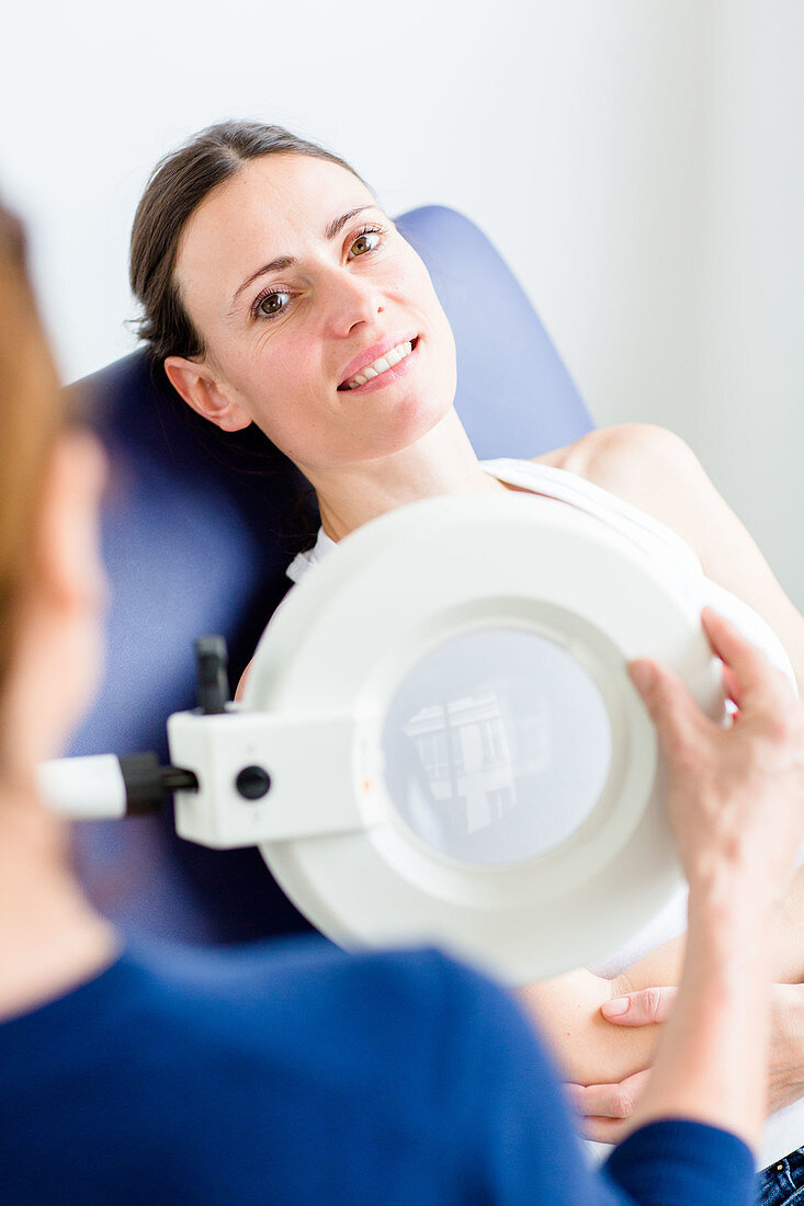 Doctor examining the skin of a woman