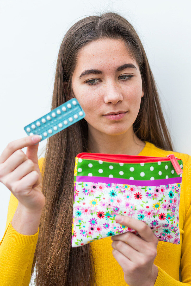 Woman holding oral contraception pill