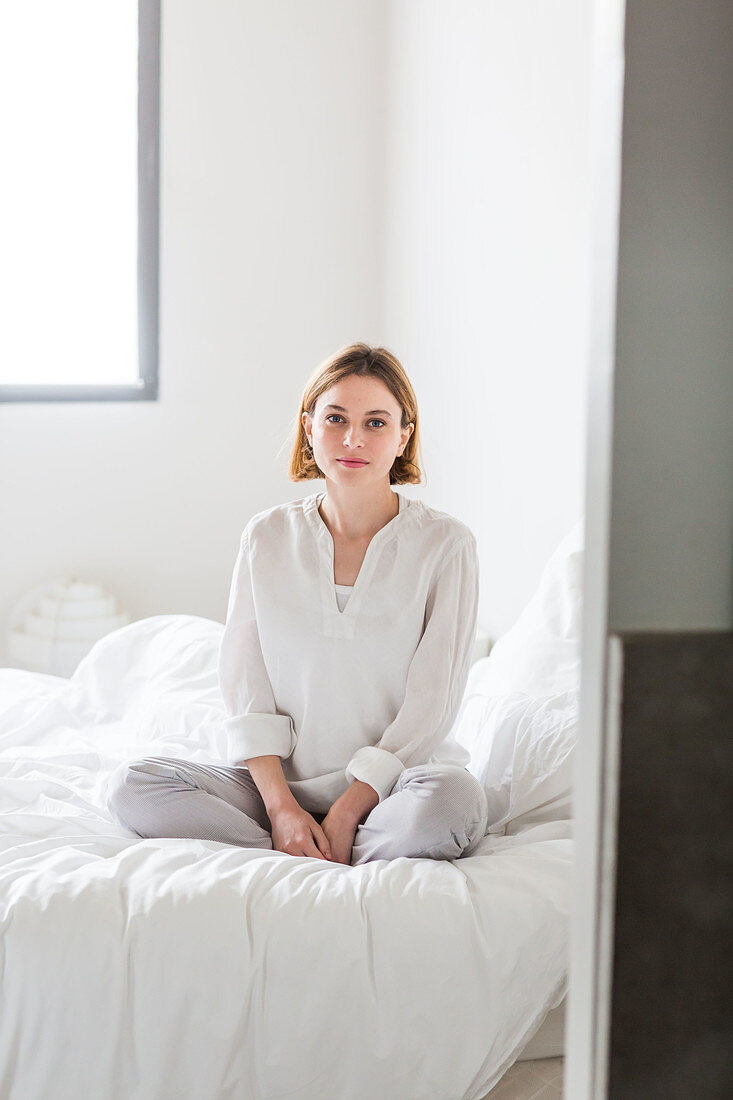 Woman sitting on her bed