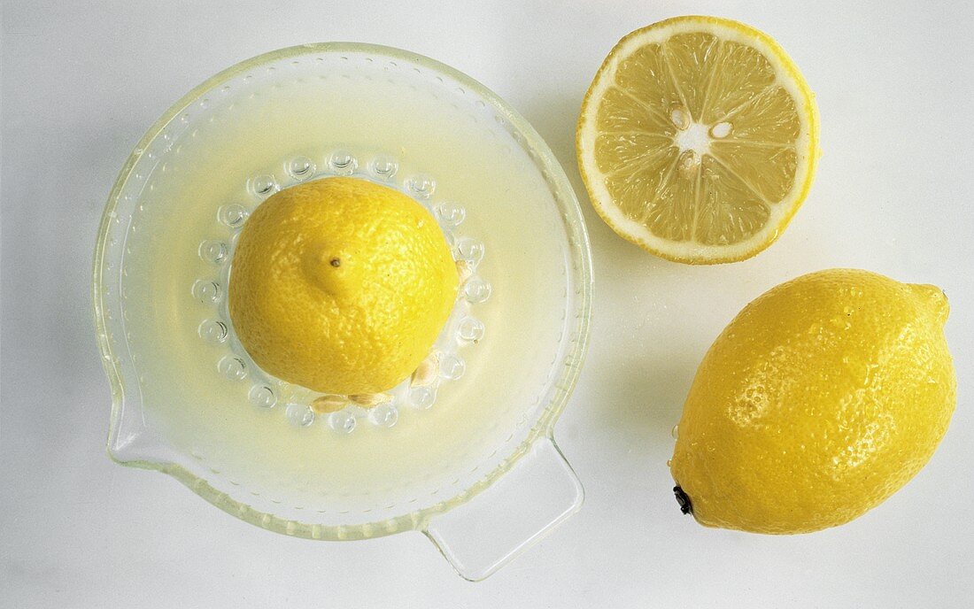 Eine Zitrone & eine Zitronenpresse mit Zitrone & Zitronensaft