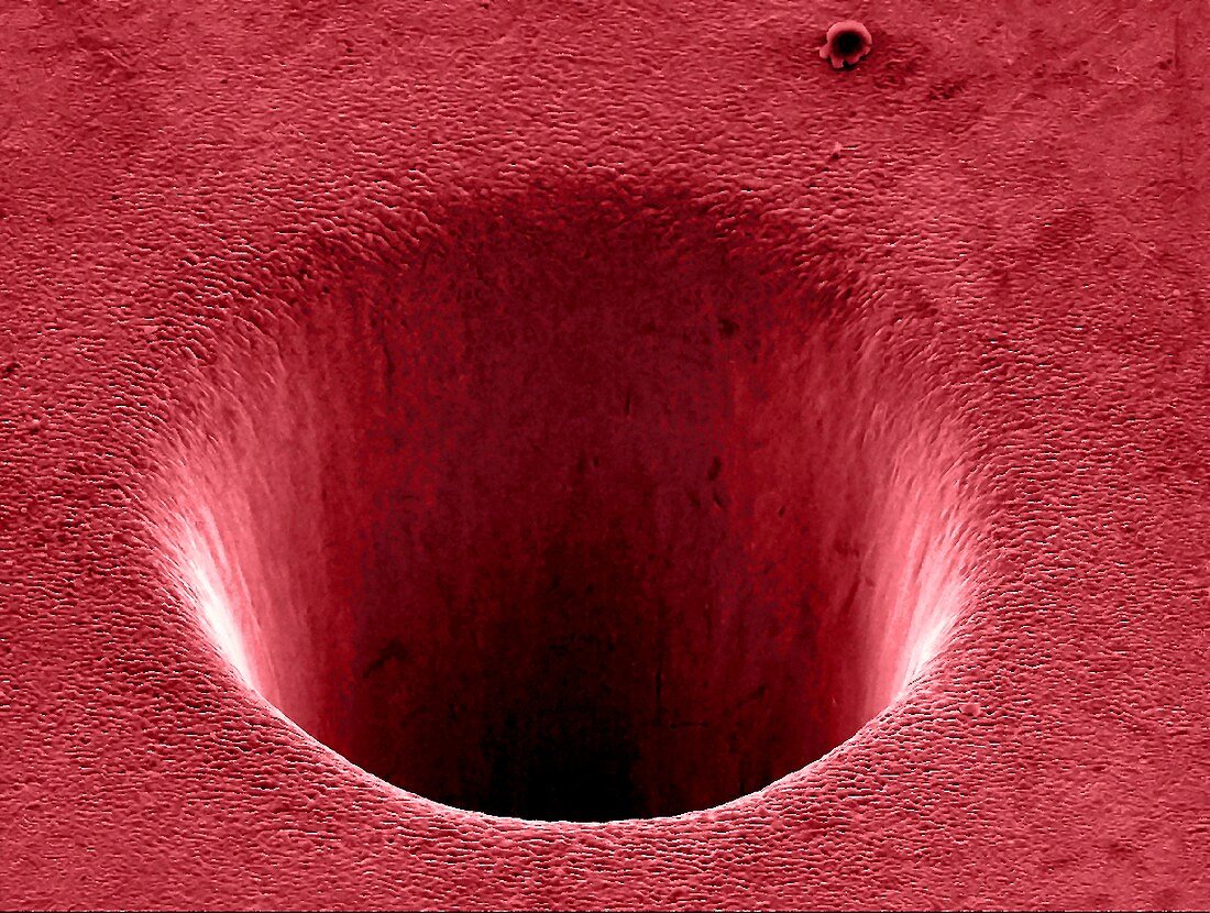 Metal crater formed by a laser, SEM