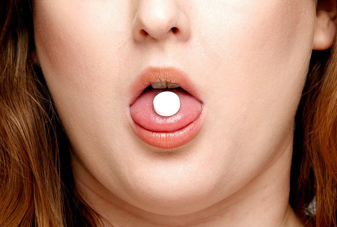 Pill on a woman's tongue